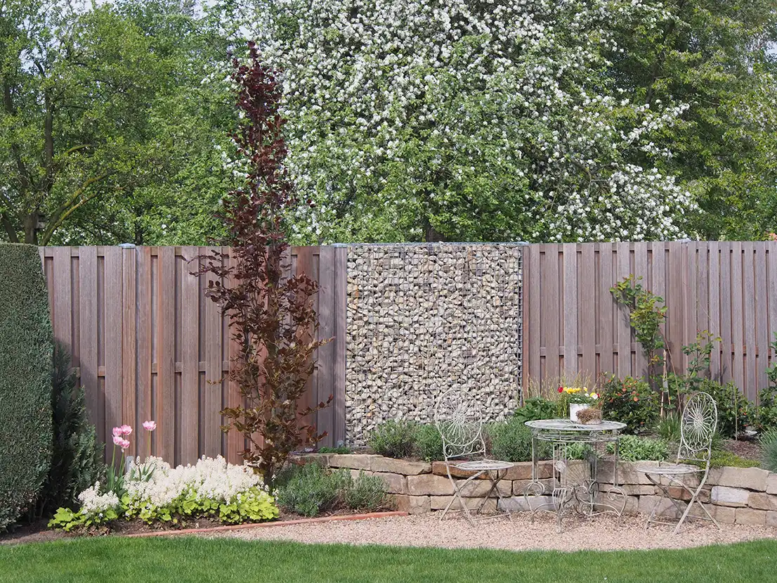 Moderner Sichtschutz aus Holz und Steinelementen im Garten